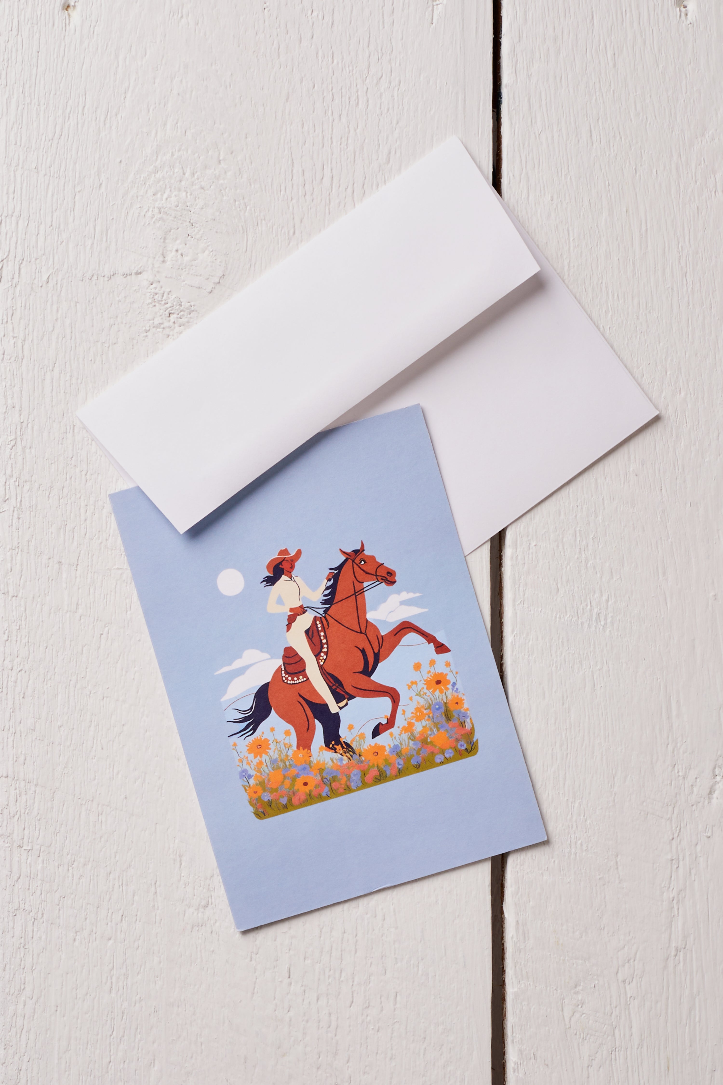 COWGIRL RIDING IN THE MEADOW GREETING CARD