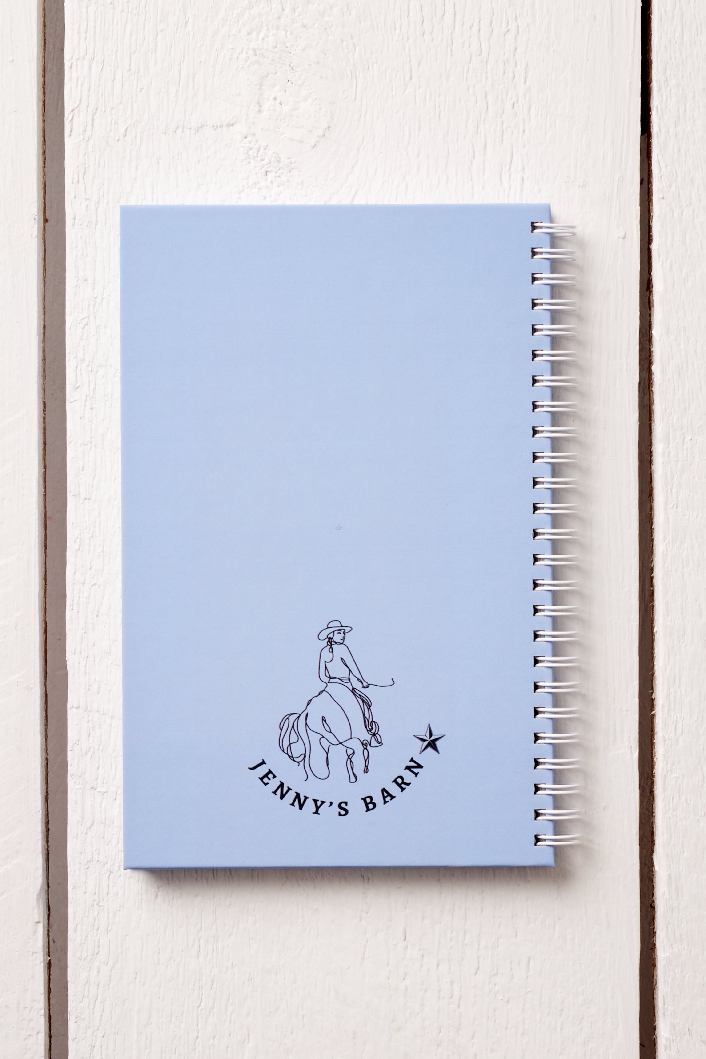 COWGIRL RIDING HORSE IN MEADOW HARDCOVER JOURNAL